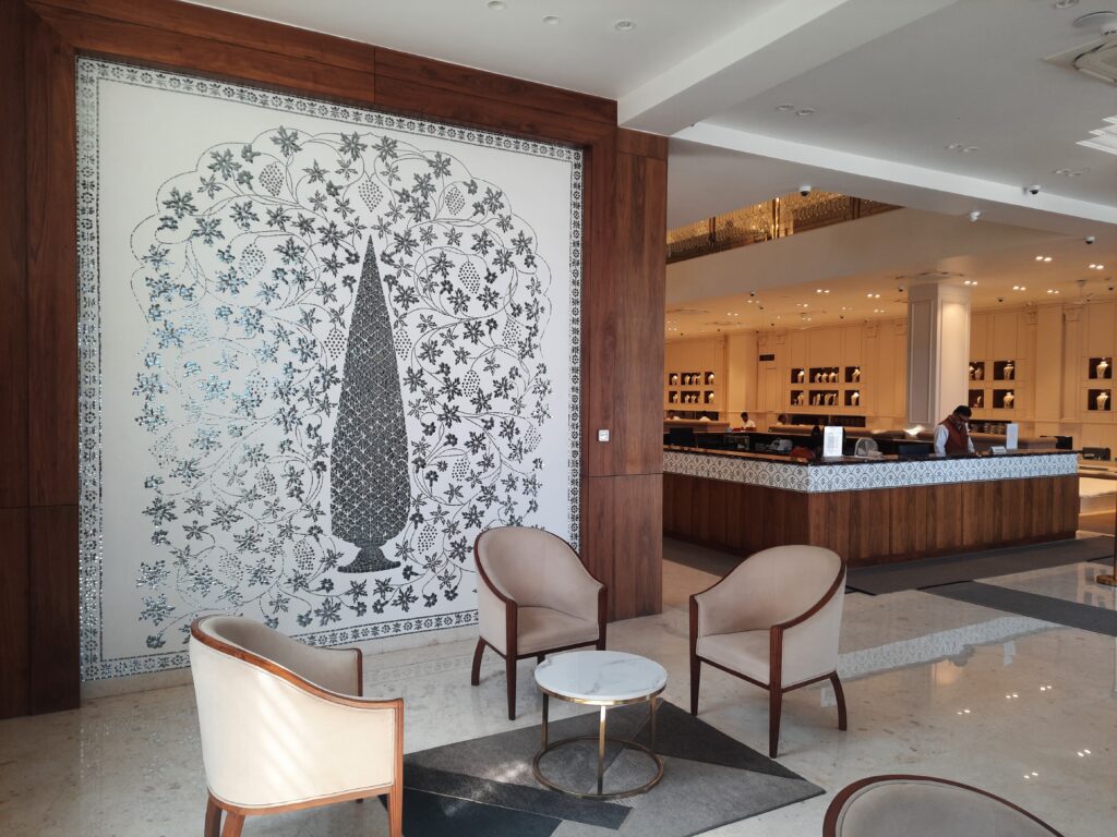 Jewelry showroom interior featuring handcrafted Thikri art wall and counter border by Yuvarti Craft Studio, reflecting light with traditional mirror inlay work
