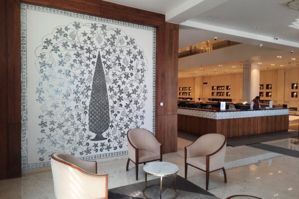 Jewelry showroom interior featuring handcrafted Thikri art wall and counter border by Yuvarti Craft Studio, reflecting light with traditional mirror inlay work