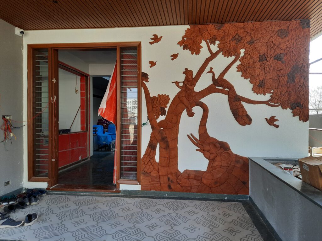 Residential interior project featuring handcrafted terracotta mural art wall and counter border by Yuvarti Craft Studio, showcasing earthy traditional clay craftsmanship.