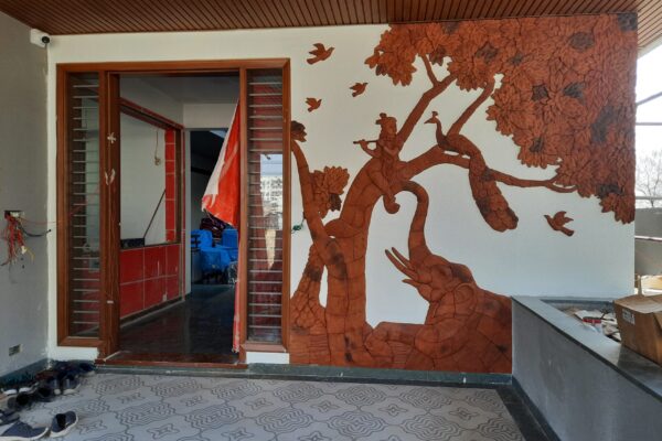 Residential interior project featuring handcrafted terracotta mural art wall and counter border by Yuvarti Craft Studio, showcasing earthy traditional clay craftsmanship.