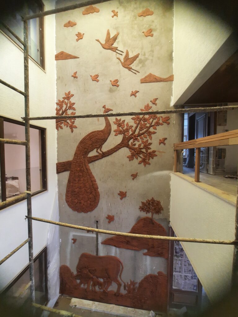 This residential interior project by Yuvarti Craft Studio showcases the timeless beauty of Terracotta Mural Art, crafted with natural clay and traditional techniques. The wall and counter border are designed with intricate relief work, bringing warmth, depth, and cultural richness to the space. Each piece is sculpted and finished by skilled Indian artisans, creating a surface that feels both earthy and artistic. Blending tradition with modern living, this terracotta installation transforms a simple wall into a storytelling canvas and the counter into a work of art. The natural tones of terracotta add harmony and sophistication, making the residence feel rooted in heritage while maintaining contemporary elegance.