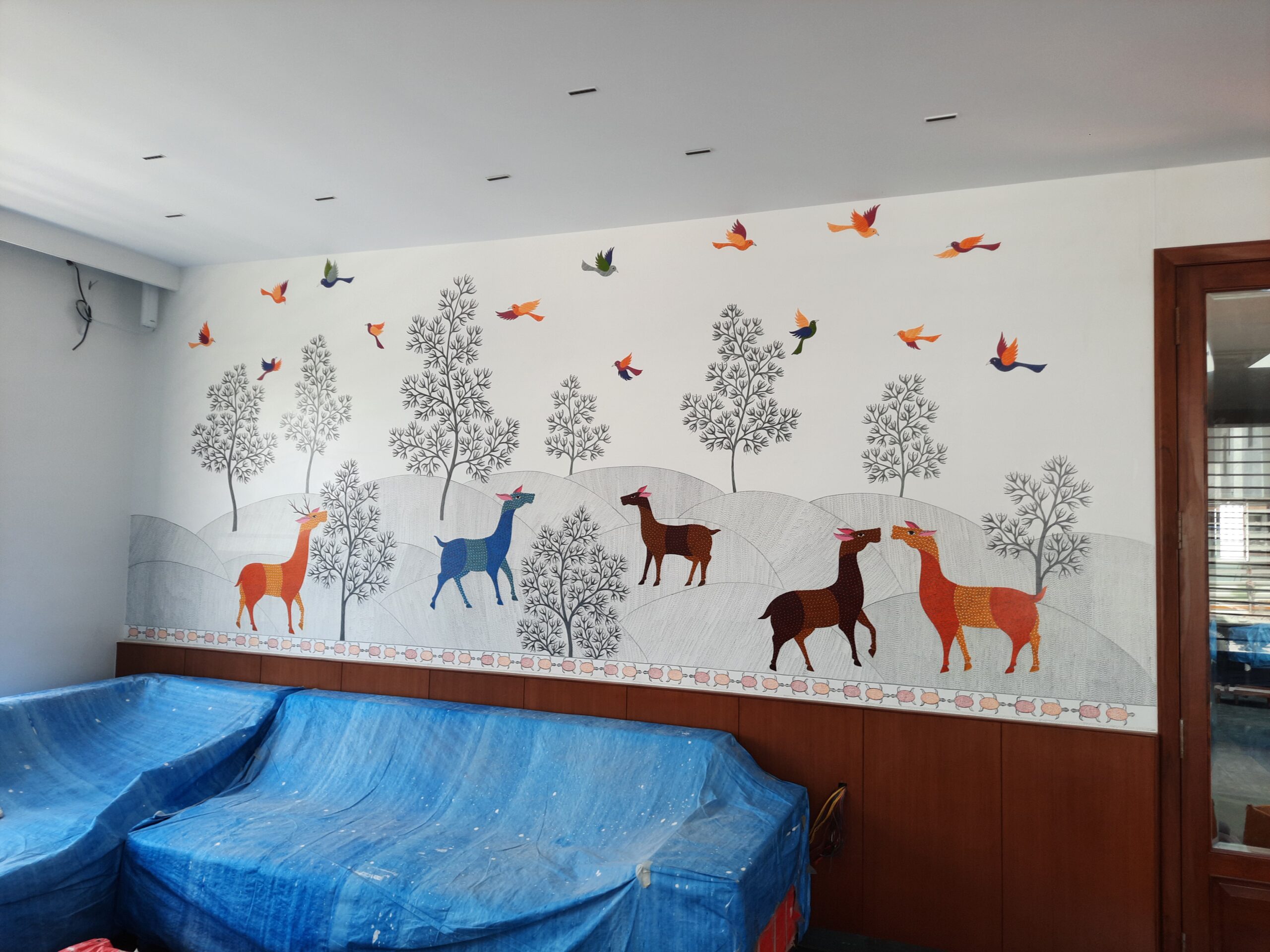 Residential project wall featuring hand-painted Gond Art by Yuvarti Craft Studio, showcasing traditional tribal patterns and nature-inspired storytelling.